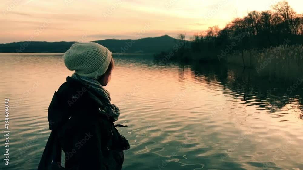 Ragazza al tramonto in riva al lago in slow motion Ragazza al tramonto in riva al lago in slow motion
