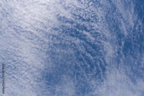 Pattern of white cirrus clouds in blue sky.
