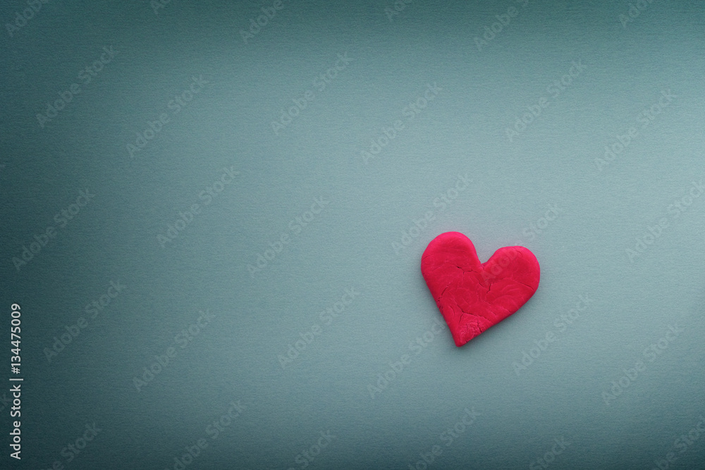 Red heart with small cracks on blue background Red heart with small cracks on blue background