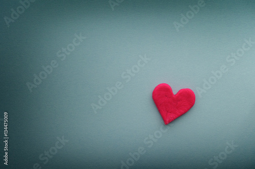 Red heart with small cracks on blue background