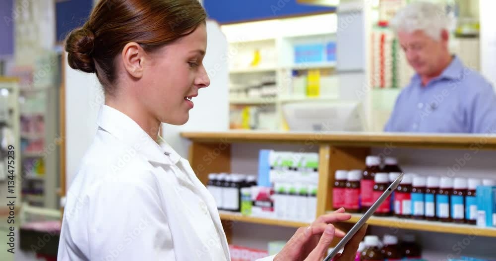 Pharmacist using digital tablet in pharmacy Pharmacist using digital tablet in pharmacy