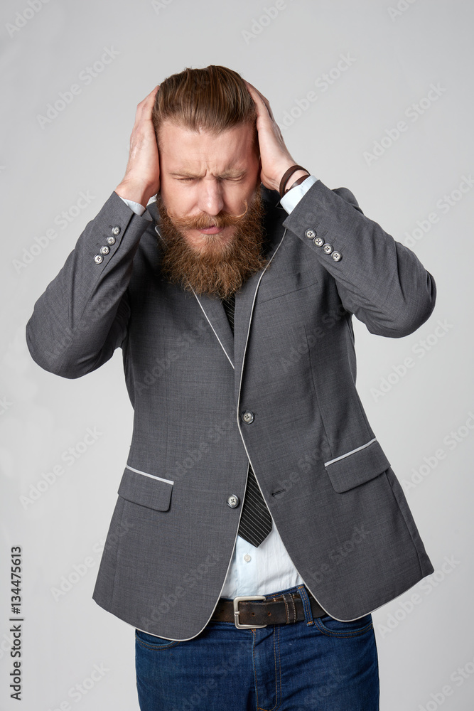 Discontent stressed hipster business man holding his head in hands Discontent stressed hipster business man holding his head in hands