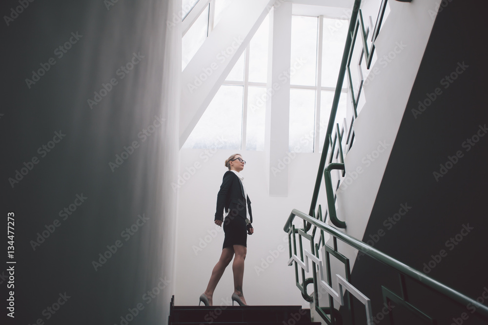 Young business woman standing on stair in the office. Young business woman standing on stair in the office.