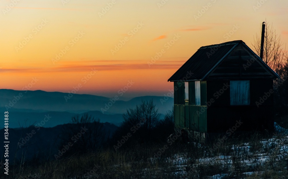 House in mountains with sunset