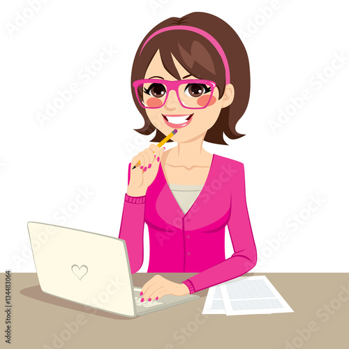 Cute young secretary wearing pink casual clothes and glasses typing on laptop and holding pencil on desk