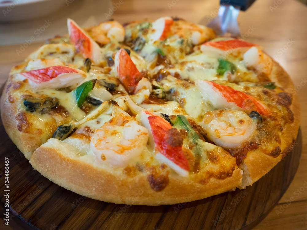 Delicious seafood pizza on wooden table Delicious seafood pizza on wooden table