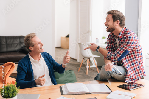 Nice delighted colleagues chatting with each other