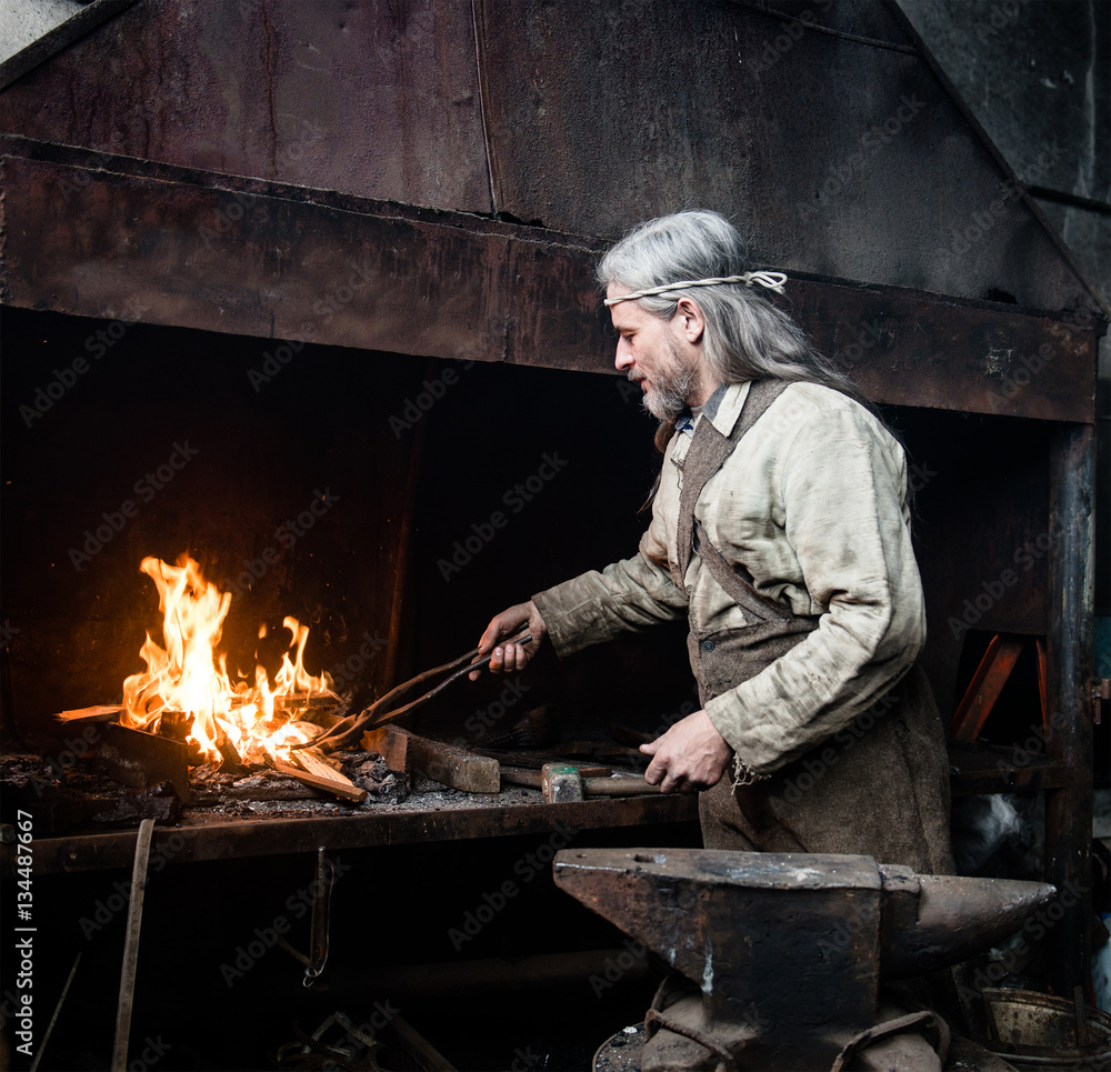 Blacksmith heats item before forging. focused on the fire Blacksmith heats item before forging. focused on the fire