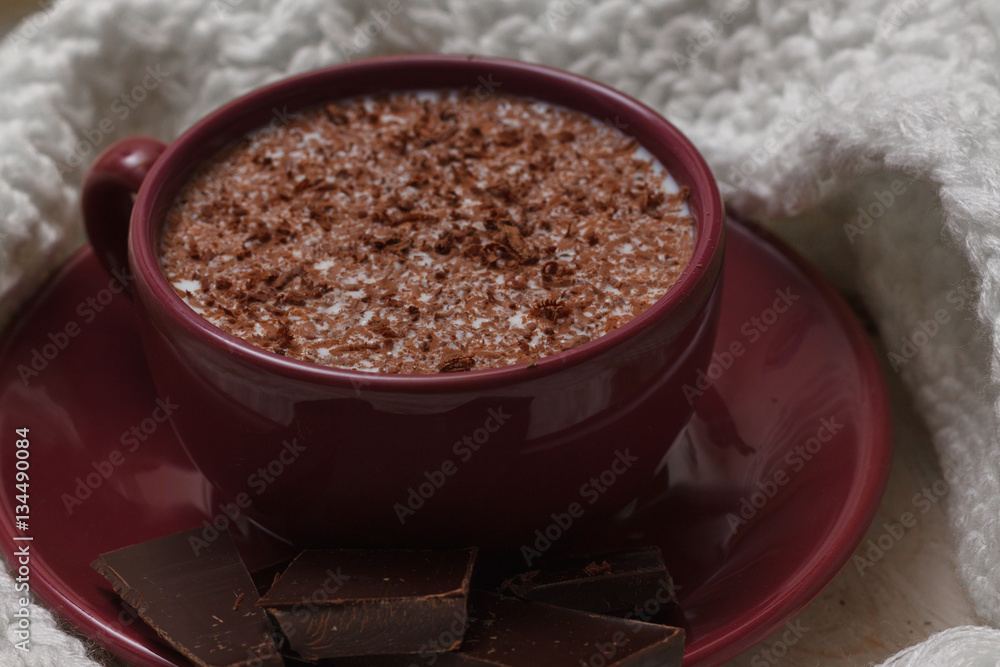 Milk chocolate in a cup on a saucer against a background of a sc