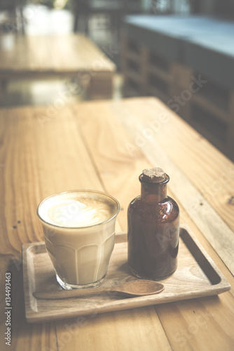 vintage art filter image of coffee latte art in cafe