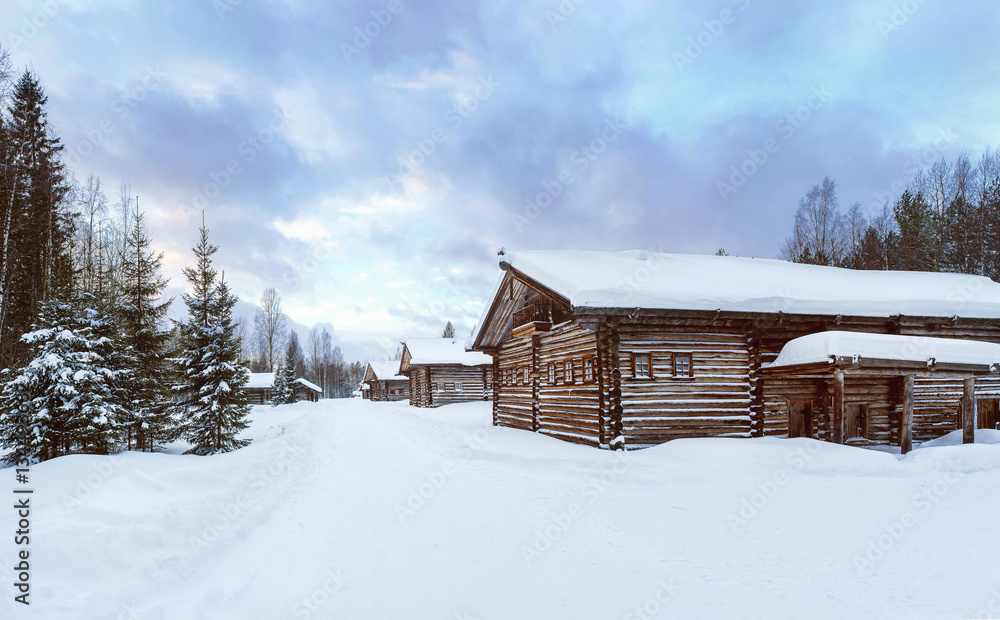 Old Village Log Houses in museum Small Karelians near Arkhangelsk, Russia. Winter sunset time.