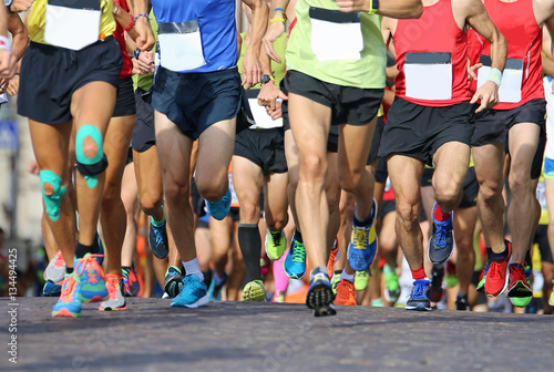 muscular legs of a large number of runners during sports race