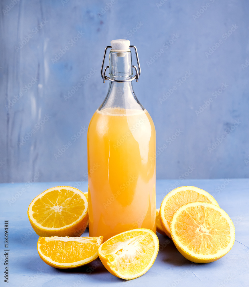 Fresh orange juice with oranges on the blue background. Free space for text . Fresh orange juice with oranges on the blue background. Free space for text .