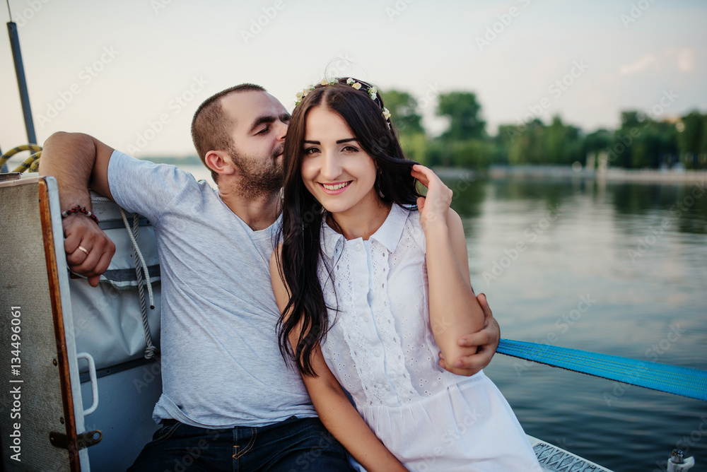 Young beautiful married couple in love at the yacht on vacation.