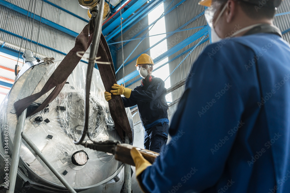 Workers handling equipment for lifting industrial boilers Workers handling equipment for lifting industrial boilers