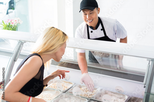 Friendly smiling deli worker helping a customer