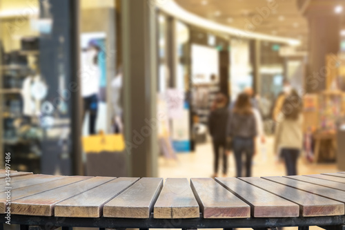 Selective foucus on Empty wooden table with the shopping mall have laday shopping background. For display or montage your products.