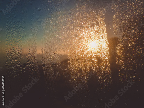 Blurry water drops on sunshine ffrozen window glass background