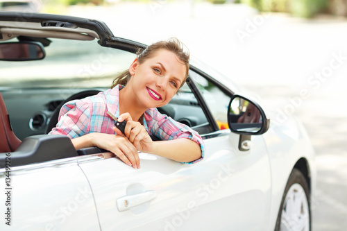 Young pretty woman sitting in a convertible car with the keys in © vladstar