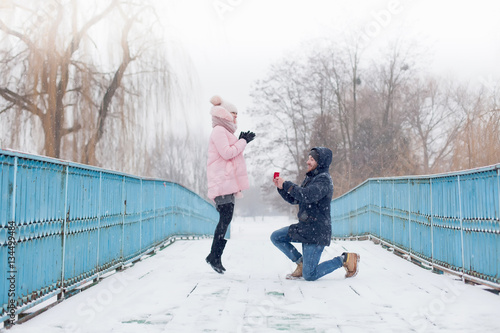 Marriage proposal. Man hold engagement ring at red box in his ha