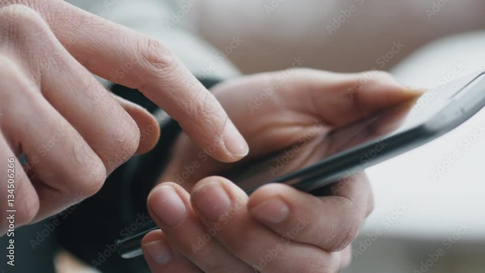 Closeup of a man using a smartphone outside during winter. Closeup of a man using a smartphone outside during winter.