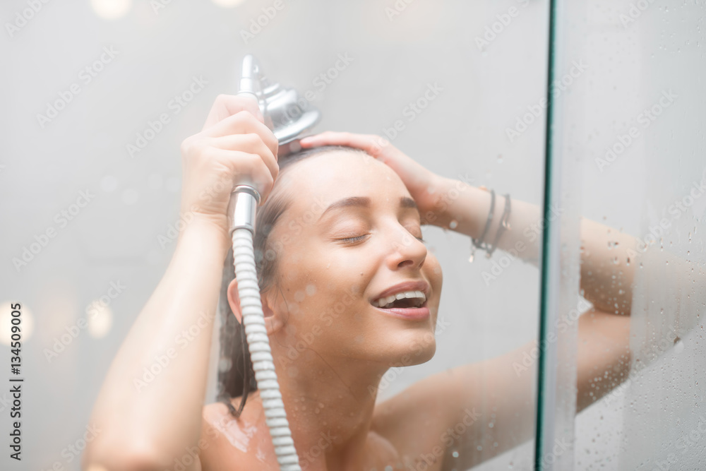 Young woman washing hair in the shower StockFoto Adobe Stock