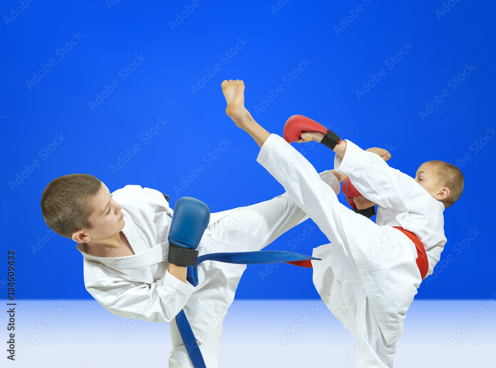 On a blue background the boys are beating kick leg On a blue background the boys are beating kick leg
