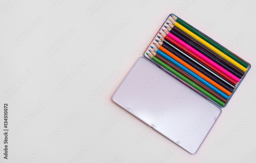 Open box with pencils on a sheet of paper Open box with pencils on a sheet of paper