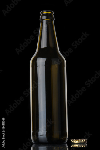 Empty beer bottle and cork on black background