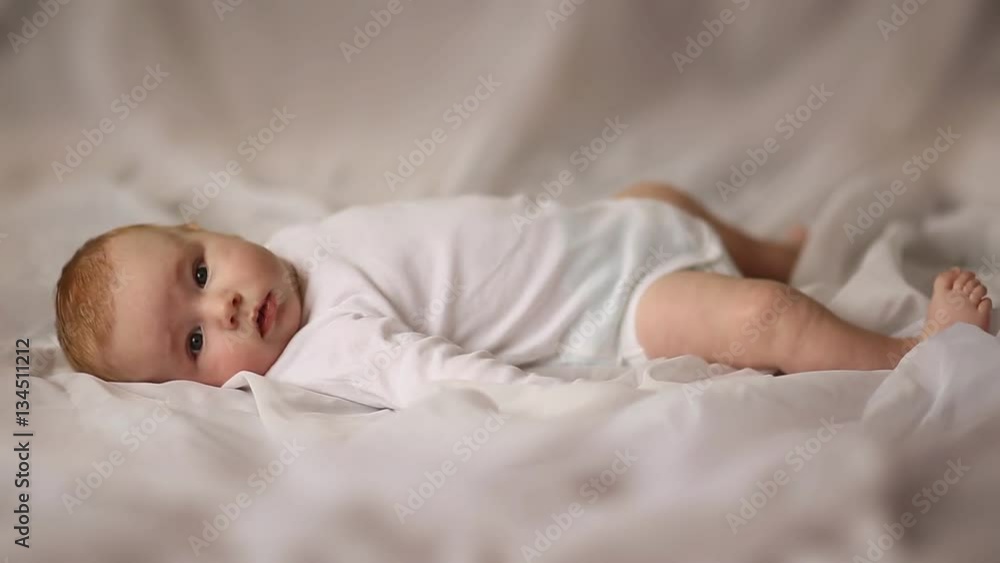 Portrait of four month old baby lying on his back on white cloth Portrait of four month old baby lying on his back on white cloth