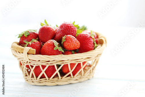 Strawberries in basket on blue wooden table