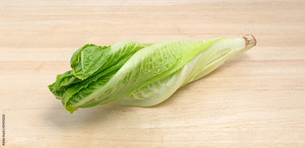 Romaine lettuce head on a wood cutting board