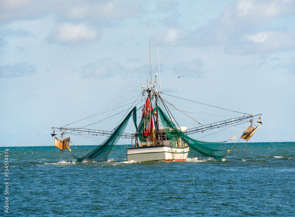 Shrimp trawler fishing boat with nets out on Gulf of Mexico waters by Florida