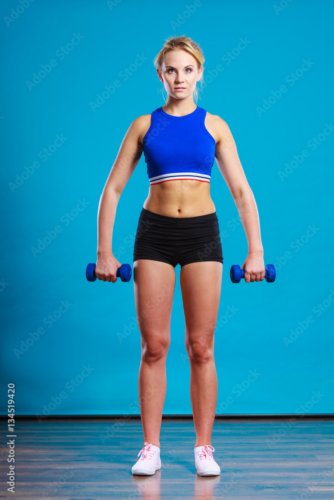Fit woman lifting dumbbells weights