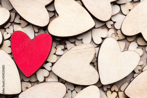 Wooden hearts, one red heart on the heart background.