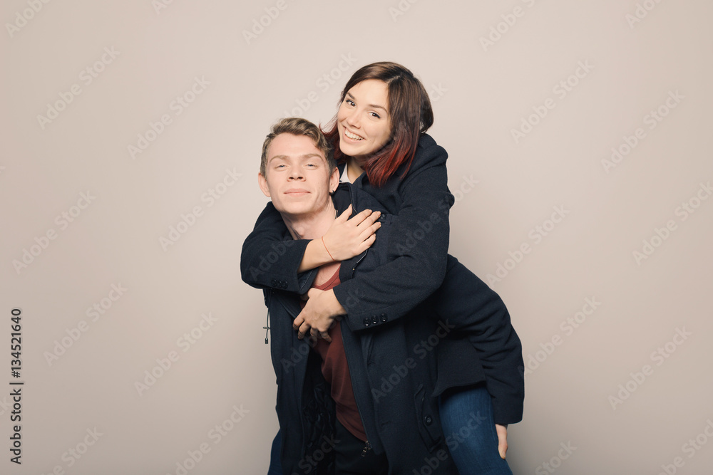 Happy young couple in winter clothes having fun in studio over white background Happy young couple in winter clothes having fun in studio over white background