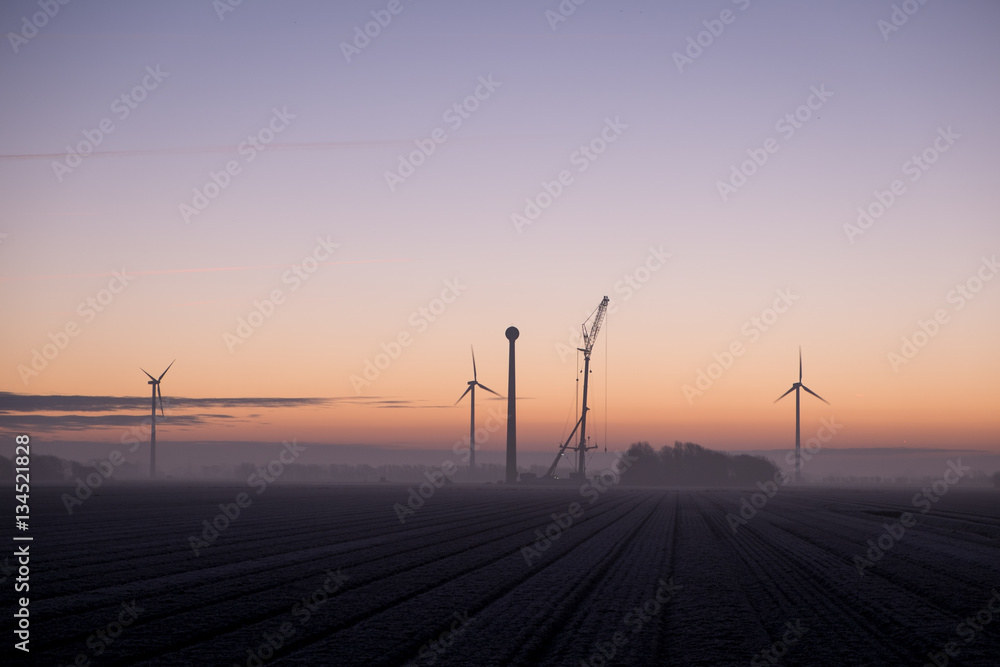 new windmill during construction at sunrise