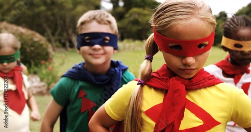 Portrait of group of kids pretending to be a super hero in the park 4k