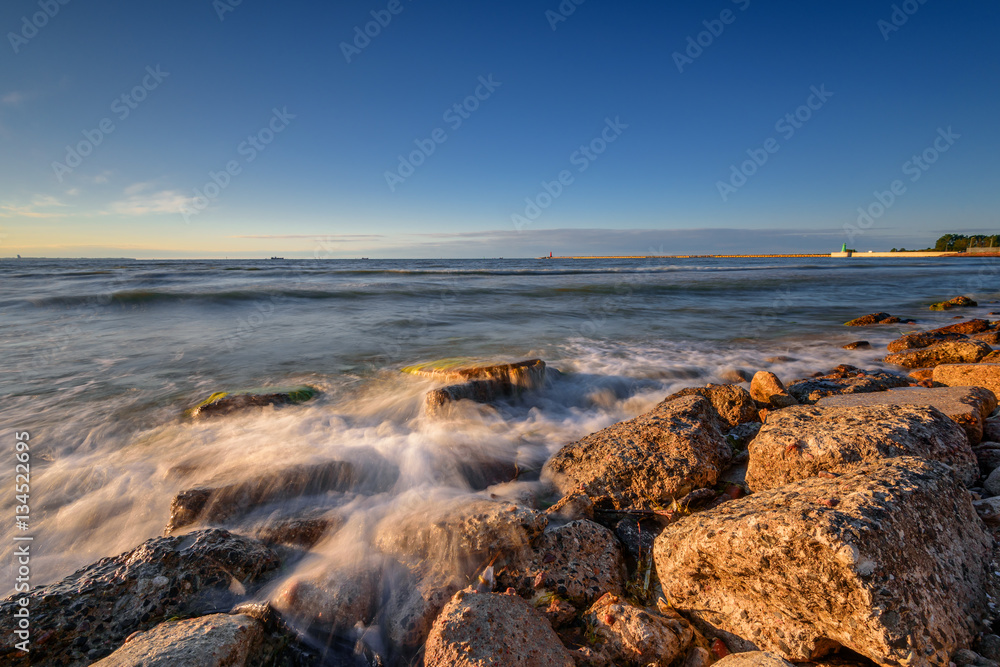 Rocky beach of the Baltic Sea at sunset light. Poland.