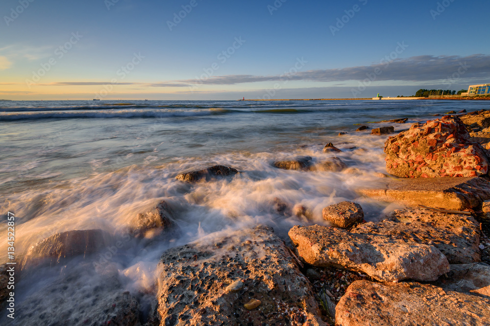 Rocky beach of the Baltic Sea at sunset light. Poland.