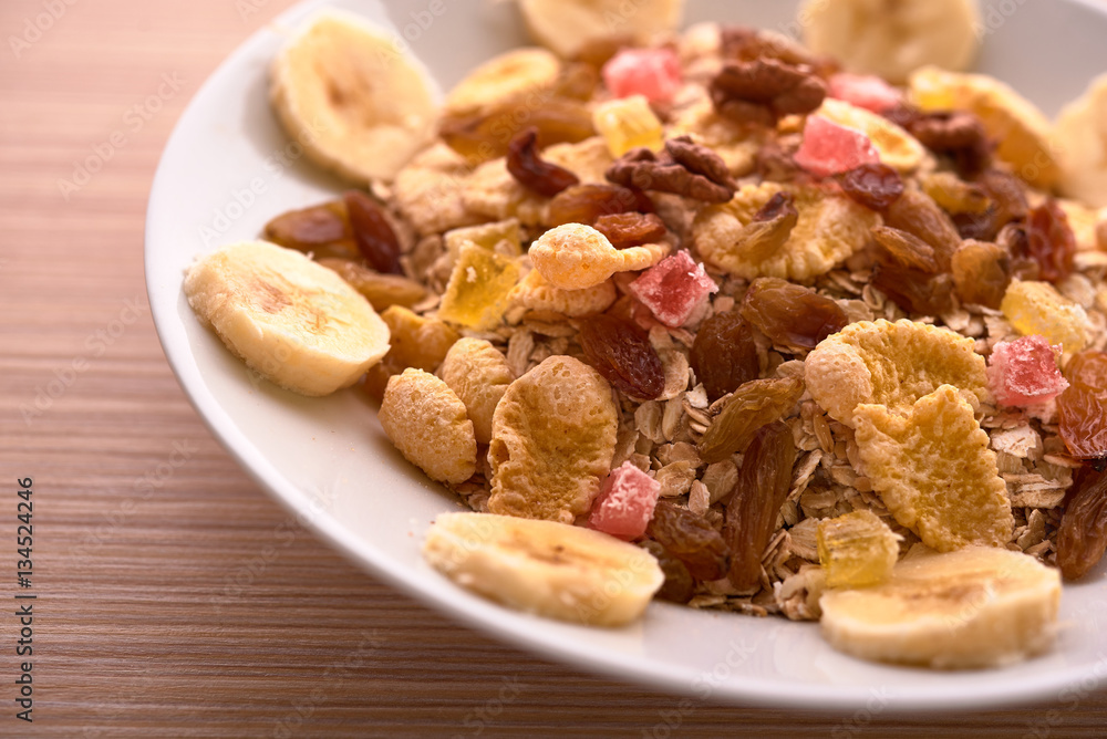 flakes with dried fruit, granola on the plate flakes with dried fruit, granola on the plate