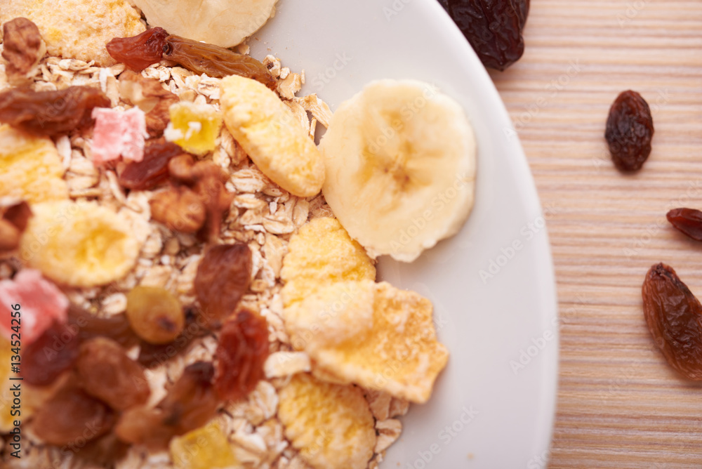 flakes with dried fruit, granola on the plate flakes with dried fruit, granola on the plate