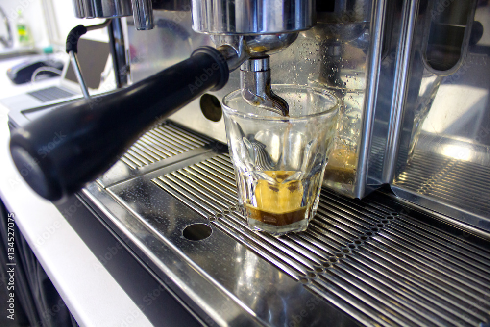 brown coffee running from coffee machine to glass brown coffee running from coffee machine to glass