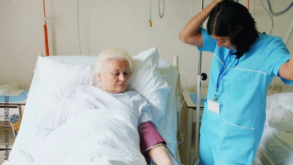 Female doctor checking blood pressure of patient at the hospital Female doctor checking blood pressure of patient at the hospital