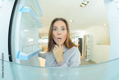 Woman looking into empty refrigerator photo