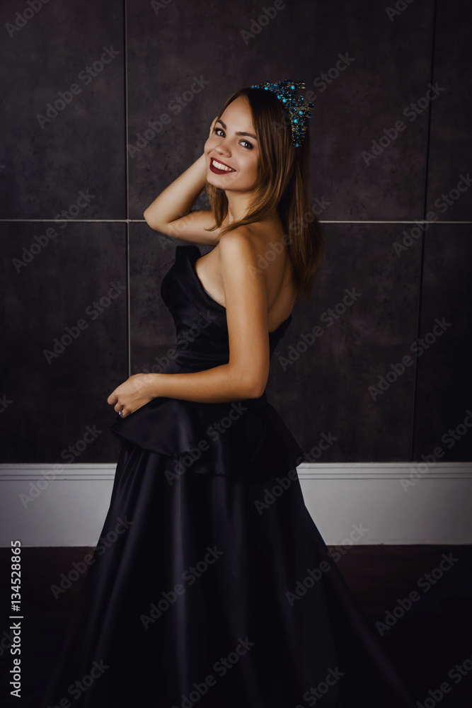 Young beautiful woman in long black dress and diamond crown Young beautiful woman in long black dress and diamond crown