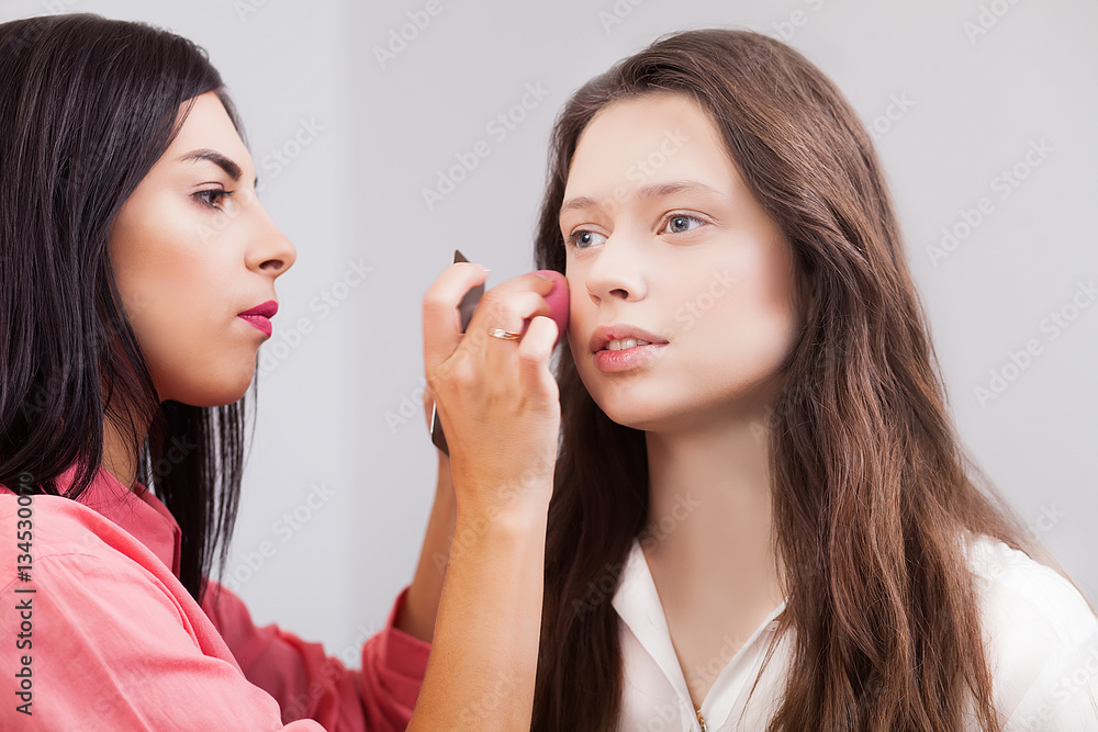 Makeup artist applies eye shadow. Beautiful woman face. Perfect makeup Makeup artist applies eye shadow. Beautiful woman face. Perfect makeup
