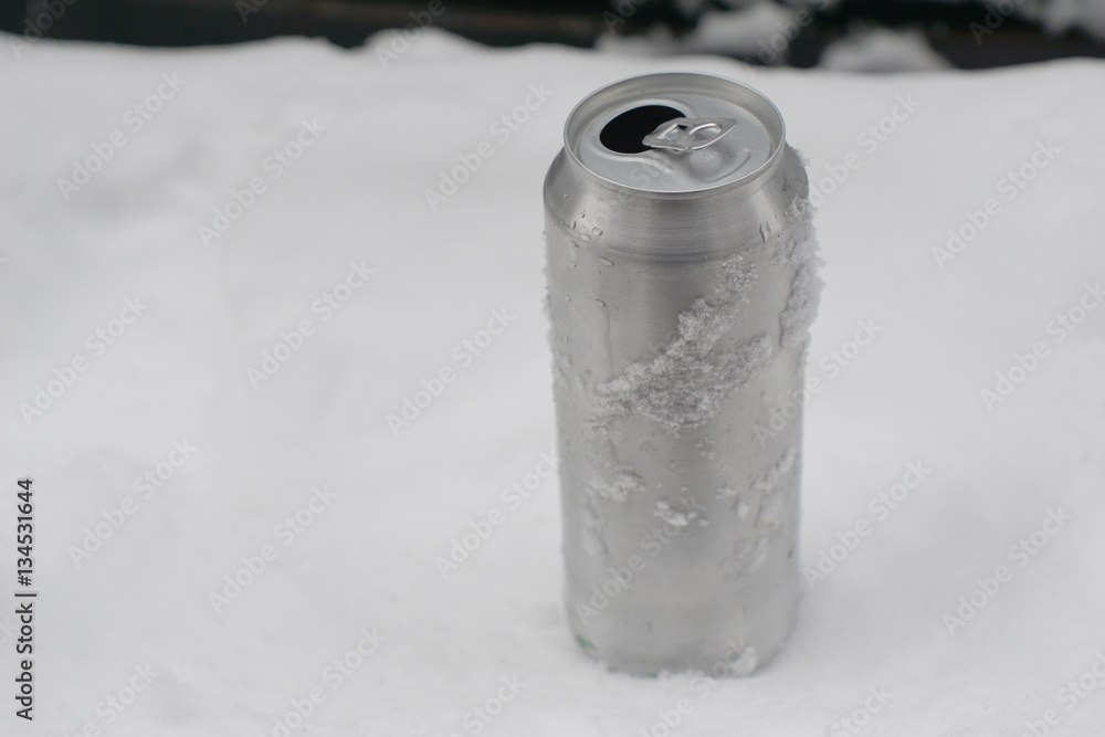 Empty can for beer or soda without labels on snow Empty can for beer or soda without labels on snow