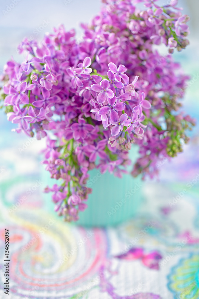 Bouquet of lilacs flowers in a vase on the table.