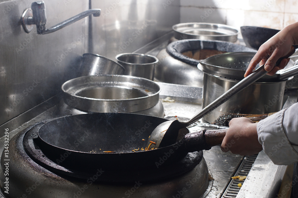Chef preparing chinese food in vok pan at restaurant Chef preparing chinese food in vok pan at restaurant